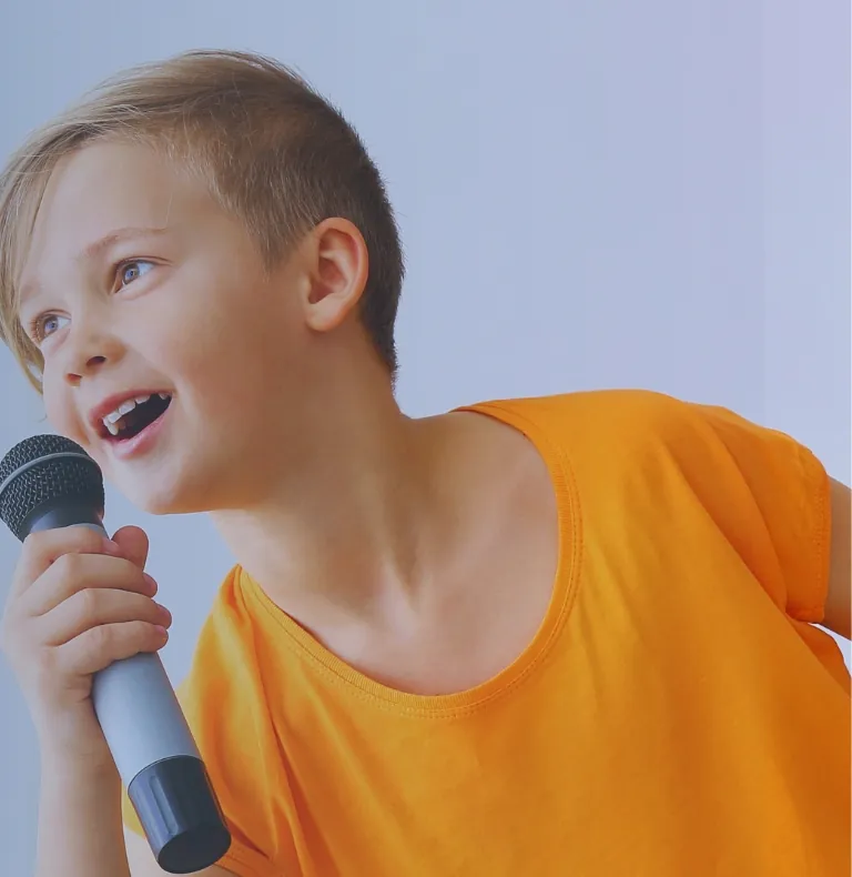 Niño sonriente hablando con un micrófono